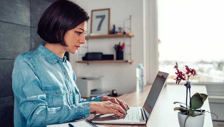 Woman wearing denim shirt using laptop in the office