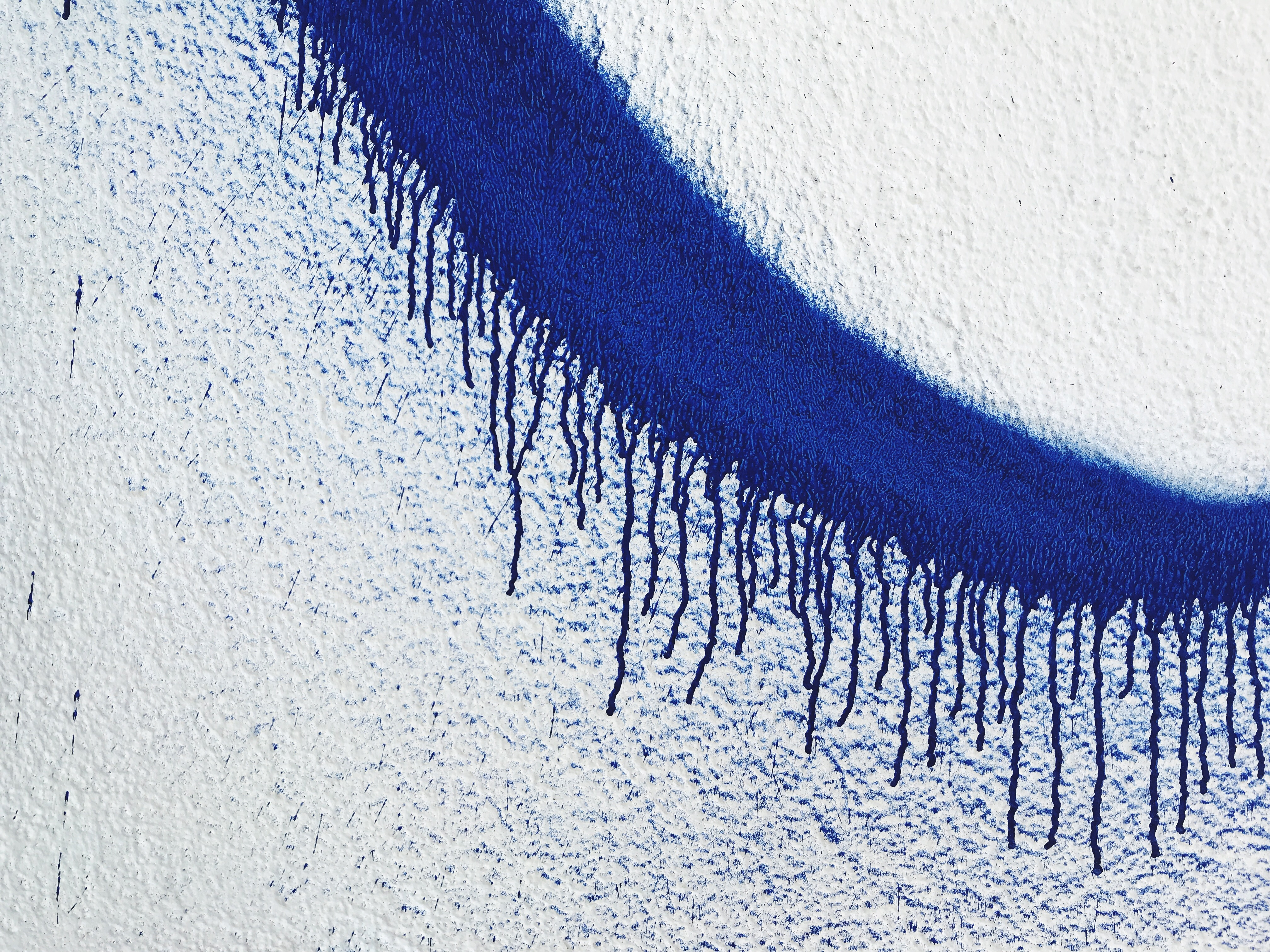 Close-Up Of Blue Spray Paint On White Wall