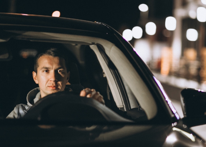 Hombre manejando de noche en su auto