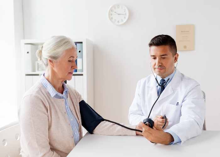 Doctor le mide la presión arterial a mujer mayor