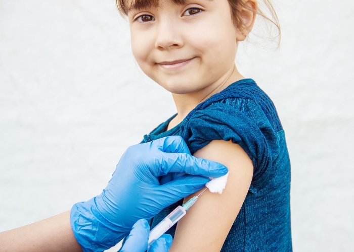 Se encuentran vacunando una niña