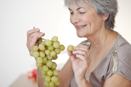 Mujer mayor comiendo uvas