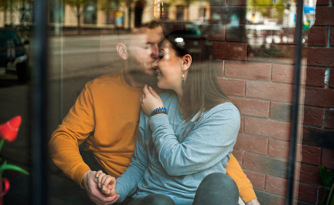 Hombre besando en la frente a mujer