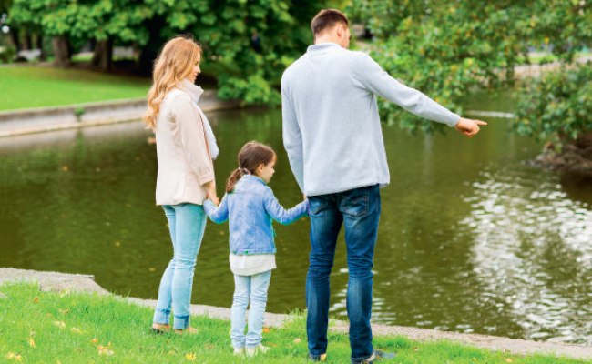 Padre, madre e hija frente a un estanque