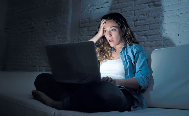 Mujer viendo computador de noche
