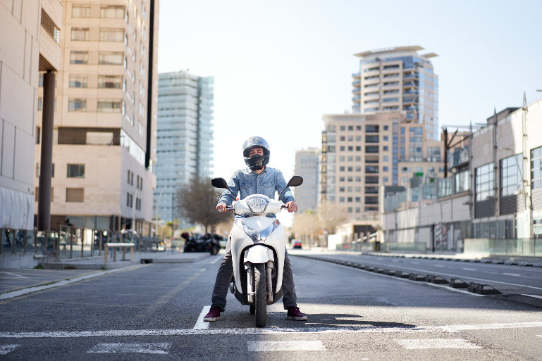 Hombre en moto blanca por la calle