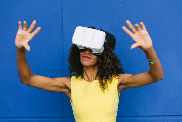 Woman using Virtual Reality Glasses against blue background